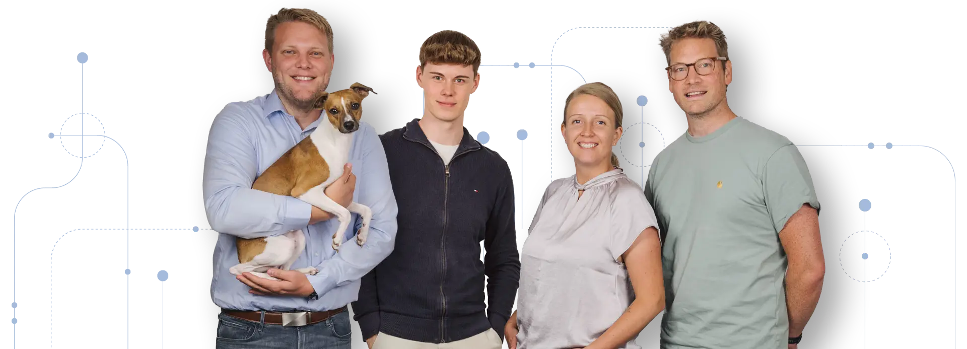 Vier Personen, darunter ein Mann mit einem Hund, posieren für ein Teamfoto.